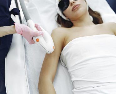 beautician conducting laser hair removal treatment