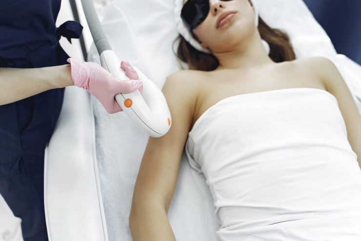 beautician conducting laser hair removal treatment